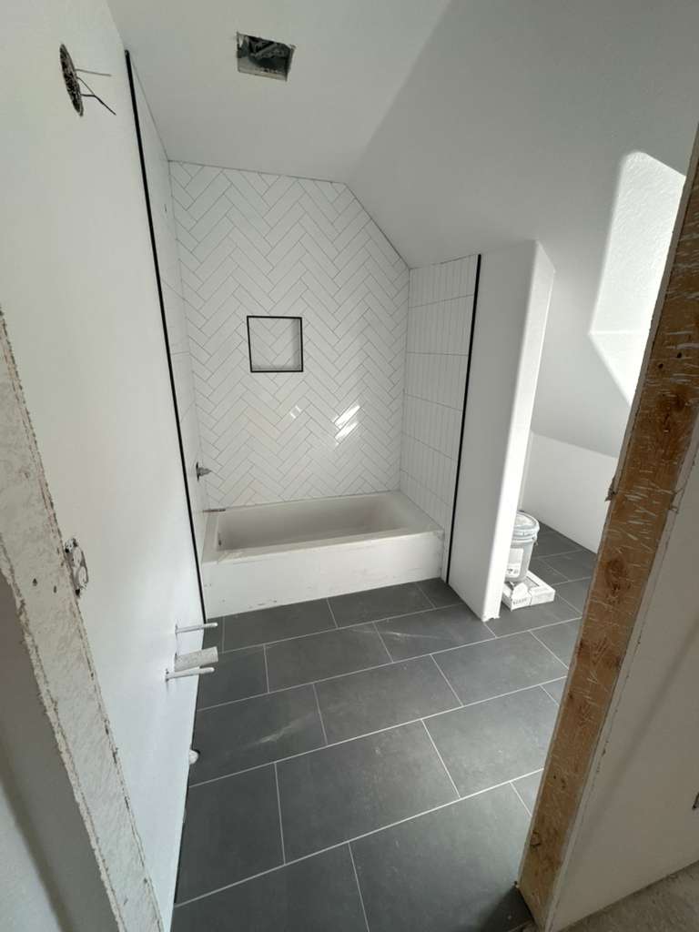 Ducha con azulejo blanco y piso de porcelanato gris instalado