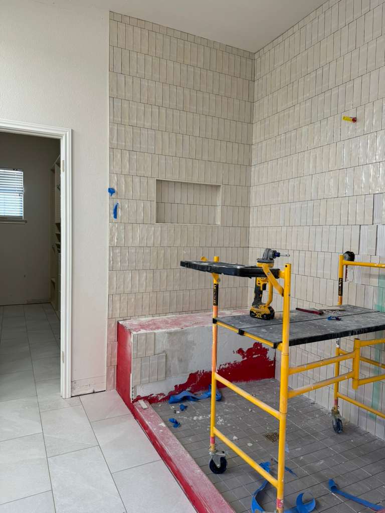 Pared de ducha alta en azulejo blanco durante la instalación