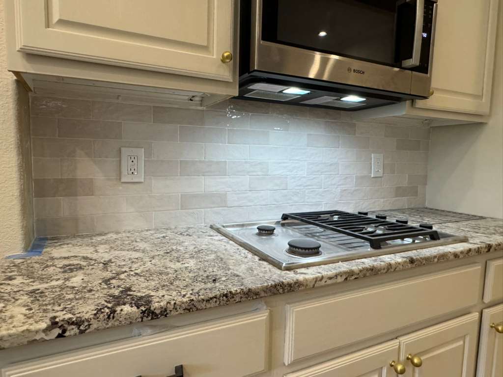 Backsplash de azulejo en cocina con encimera de granito