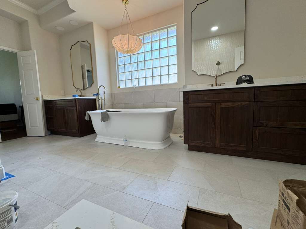 Baño principal con piso de porcelanato claro y bañera exenta